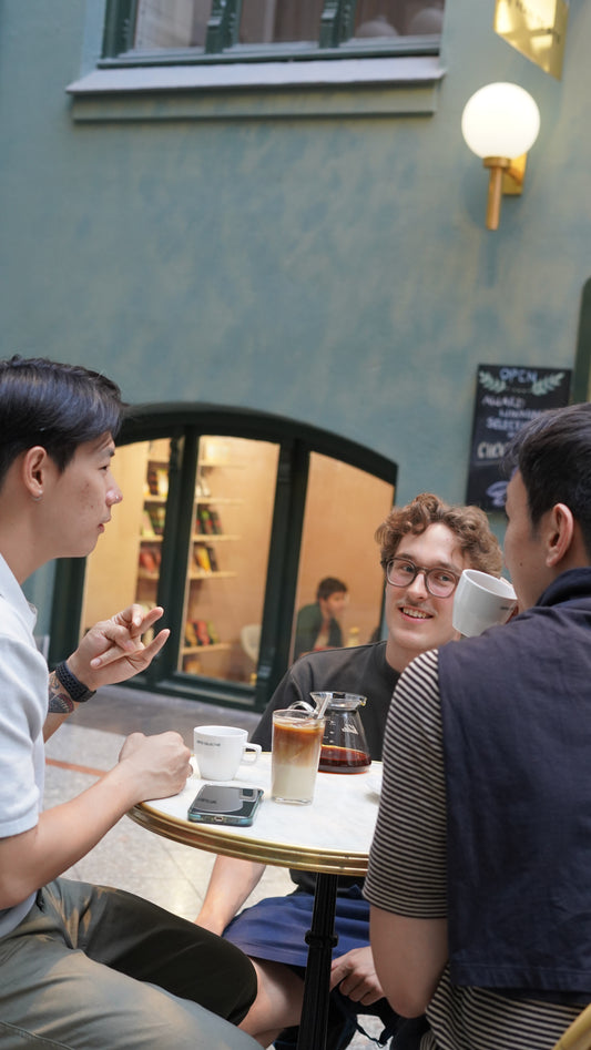 People sitting around a table in a casual setting with drinks.